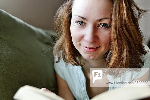 Porträt einer jungen Frau  die ein Buch hält