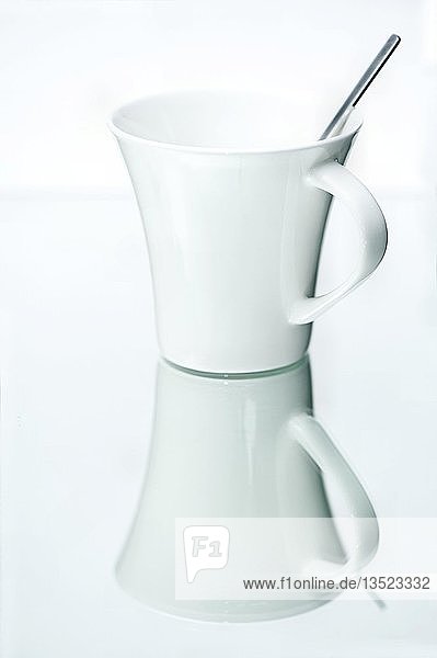Kaffeetasse mit einem Löffel auf einer spiegelnden Oberfläche