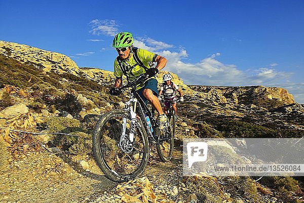 Zwei Mountainbiker radeln in felsigem Gelände  Red Beach  Matala  Kreta  Griechenland  Europa