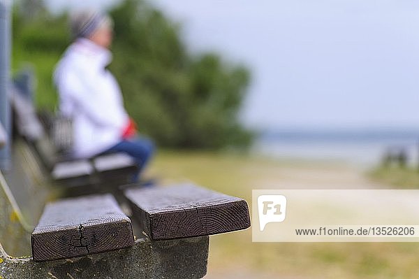 Eine Frau sitzt auf einer Bank an der Ostseeküste  Insel Poel  Mecklenburg-Vorpommern  Deutschland  Europa