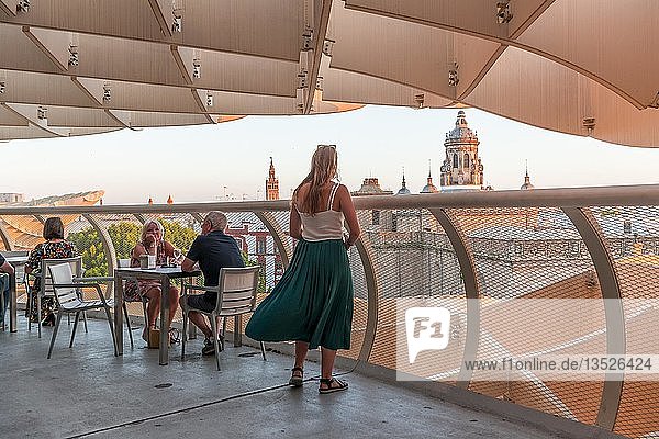 Woman looks at cathedral  restaurant and bar on the Metropol Parasol  curved wooden structure  Plaza de la Encarnacion  Seville  Andalusia  Spain  Europe