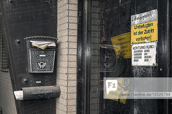 Verschlossene Haustür mit Verbotsschildern und einem überquellenden Briefkasten  Borschemich  Nordrhein-Westfalen  Deutschland  Europa