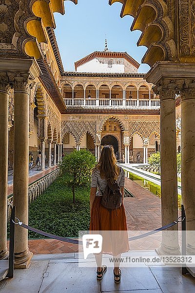 Woman in a Red Dress  Patio de las Doncellas  Court of the Maidens  an Italian Renaissance courtyard  with stucco arabesques in Mudejar style  Alcazar  Royal Palace of Seville  Sevilla  Spain  Europe