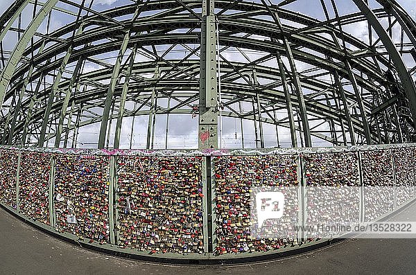Vorhängeschlösser Liebesschlösser am Sicherheitsgitter das den Fußweg von den Eisenbahngleisen an der Hohenzollernbrücke trennt Köln Nordrhein-Westfalen Deutschland Europa