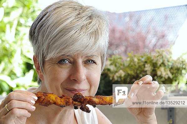 Woman with grilled chicken on a balcony