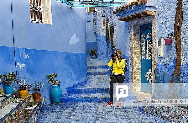 Young woman photographed  Blue house walls  Medina of Chefchaouen  Chaouen  Tangier-Tétouan  Kingdom of Morocco