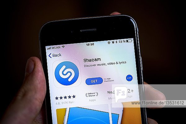 Hand hält iPhone mit Shazam App im Apple App Store  Musikerkennung  App-Symbol  Anzeige auf einem Bildschirm eines Mobiltelefons  iPhone  iOS  Smartphone  Deutschland  Europa