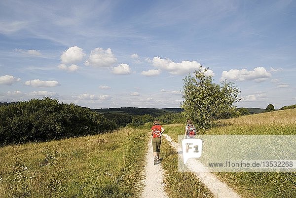 Two hikers on a dirt road near Riedenburg in Altmuehltal Nature Park  Bavaria  Germany  Europe