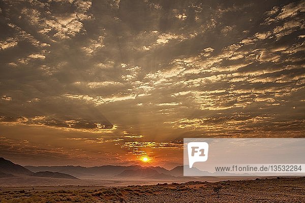 Sonnenaufgang mit bewölktem Himmel über den Bergen  Namib-Wüste  Namibia  Afrika