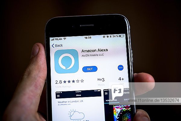 Hand hält iPhone mit Amazon Alexa App im Apple App Store  Virtueller Assistent  Künstliche Intelligenz  App-Symbol  Anzeige auf einem Bildschirm eines Mobiltelefons  iPhone  iOS  Smartphone  Deutschland  Europa