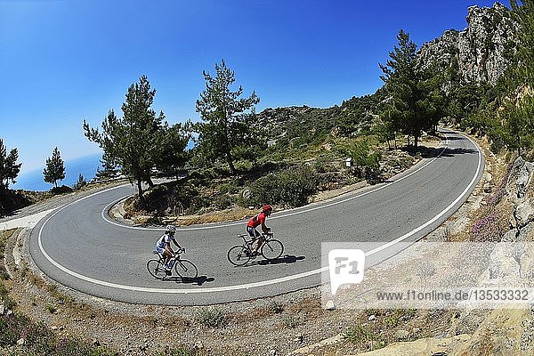 Zwei Rennradfahrer auf kurviger Straße bei Kalamafka Kreta Griechenland Europa