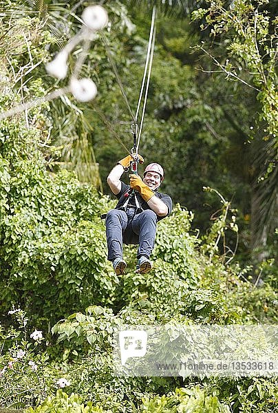 Mann  48 Jahre  fährt an einer Zipline durch den Dschungel  Provinz Samaná  Dominikanische Republik  Mittelamerika