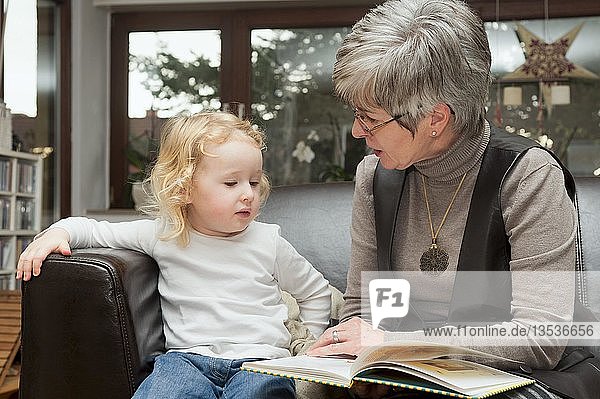 Großmutter liest ihrer Enkelin ein Buch vor