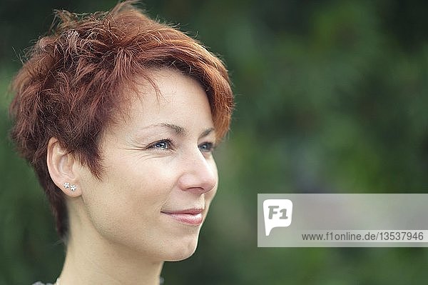 Lächelnde junge Frau mit kurzen roten Haaren  Porträt