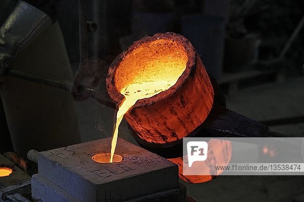 Arbeiten in einer Gießerei flüssige Bronze wird in Form gegossen Deutschland Europa