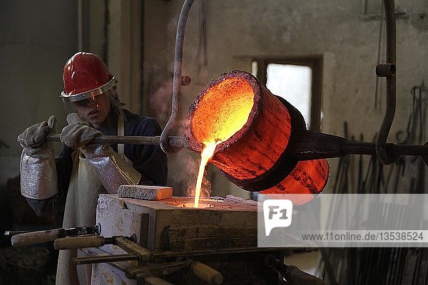 Arbeiten in einer Gießerei flüssige Bronze wird in Form gegossen Deutschland Europa