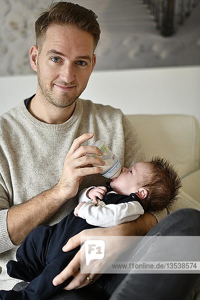 Young father feeding infant  4 weeks  with bottle  Baden-Württemberg  Germany  Europe