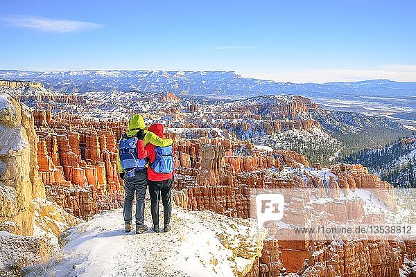 Touristen mit Blick auf das Amphitheater  bizarre schneebedeckte Felslandschaft mit Hoodoos im Winter  Rim Trail  Bryce Canyon National Park  Utah  USA  Nordamerika