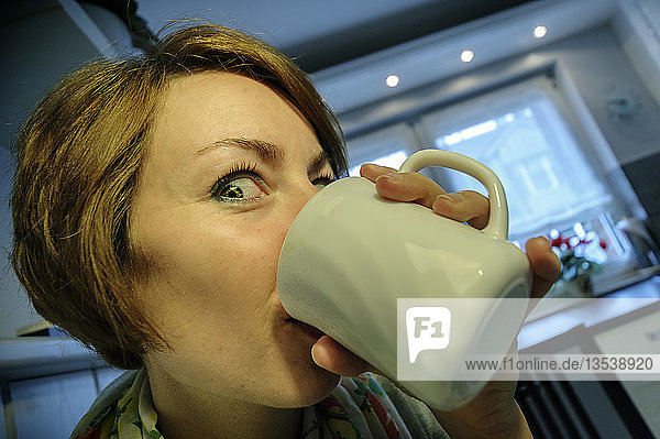 Junge Frau trinkt enthusiastisch Kaffee  Deutschland  Europa