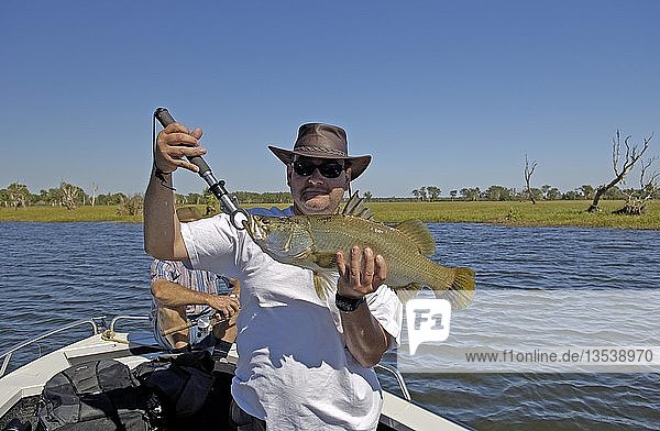 Tourist präsentiert stolz seinen geangelten Barramundi Barsch Lates calcarifer Kakadu NP Northern Territory Australien Ozeanien