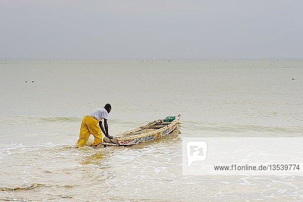 Fischer beim Auslaufen mit seinem traditionellen Fischerboot  Saly  Region Thiès  Senegal  Afrika