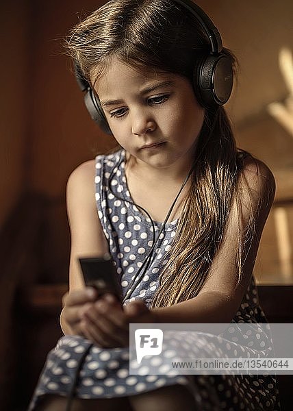 Girl  5 years  listening to music with headphones  Germany  Europe