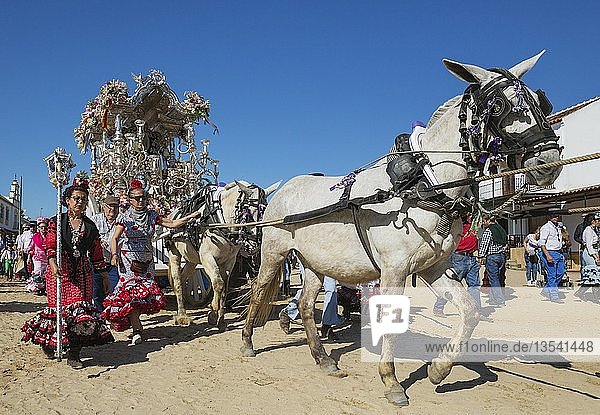 Frauen in bunten Kleidern neben einem verzierten Wagen Pfingsten Wallfahrt von EL Rocio Huelva-Provinz Andalusien Spanien Europa
