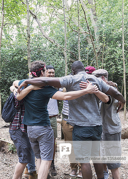 Männergruppe  die sich umarmt  Wandern im Wald