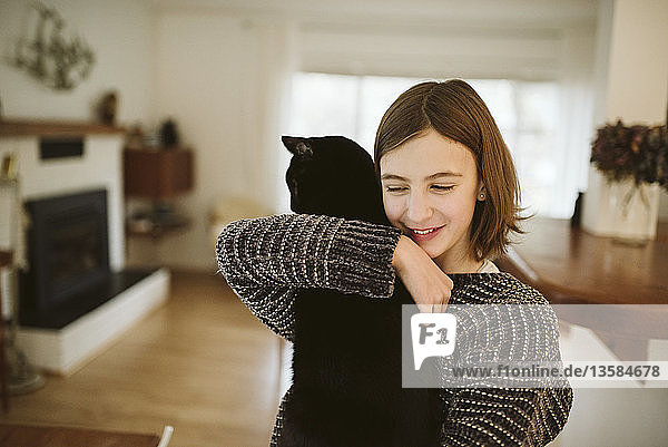 Zärtliches Mädchen hält schwarze Katze
