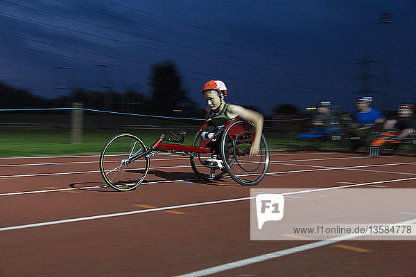 Jugendlicher querschnittsgelähmter Sportler rast im Rollstuhlrennen über die Sportstrecke