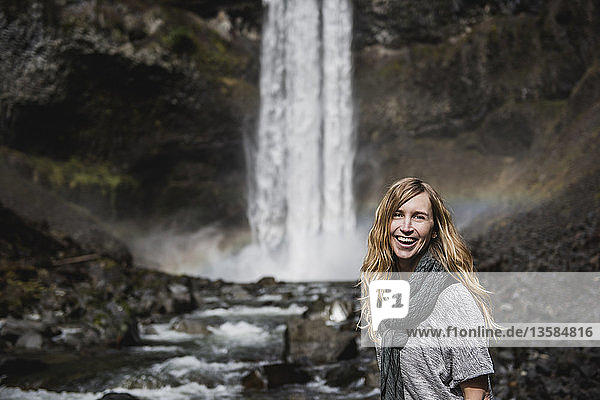 Portrait smiling  confident woman hiking along waterfall  Whistler  British Columbia  Canada
