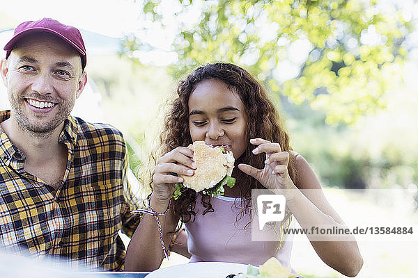 Father and daughter enjoying barbecue hamburger