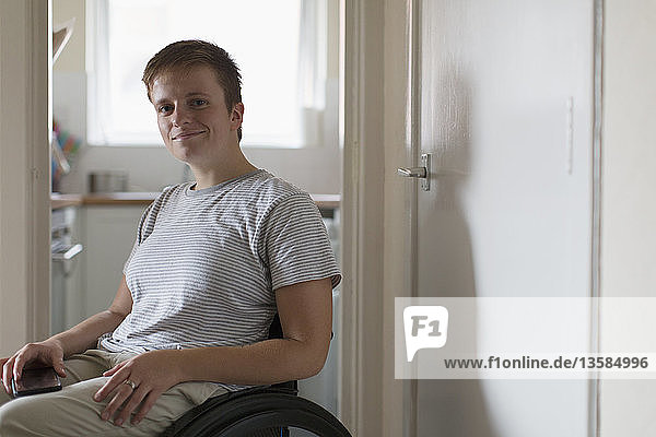 Porträt selbstbewusste junge Frau im Rollstuhl zu Hause