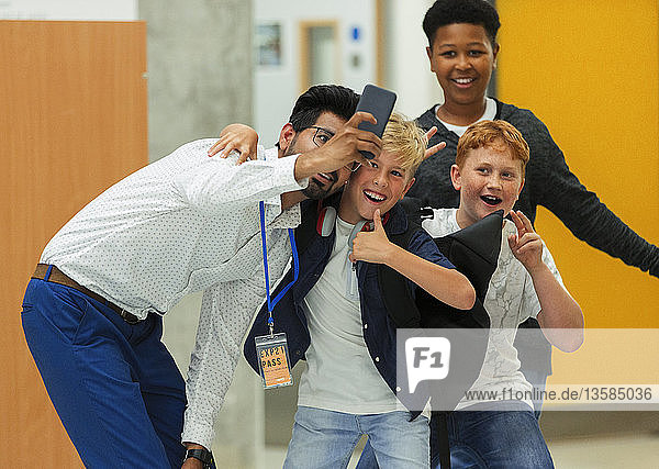 Schüler der Junior High und männlicher Lehrer machen Selfie mit Smartphone