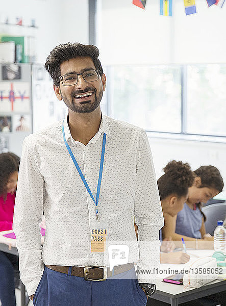 Porträt glücklicher männlicher Lehrer im Klassenzimmer