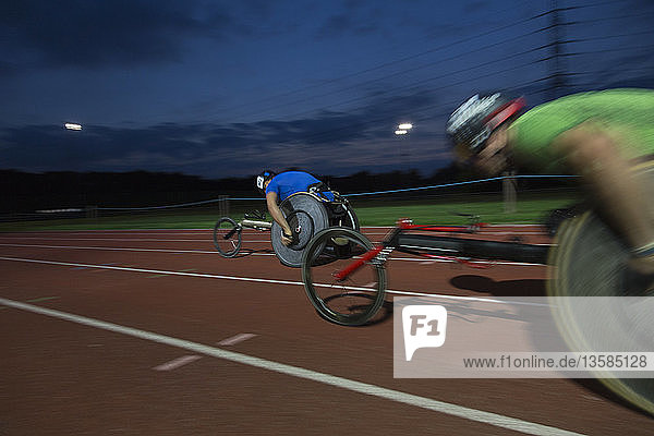 Querschnittsgelähmte Athleten rasen bei einem nächtlichen Rollstuhlrennen über eine Sportstrecke