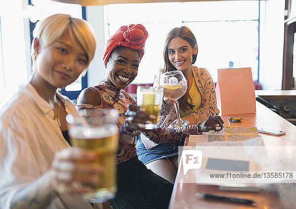Porträt lächelnd  zuversichtlich  junge Frauen Freunde Toasting Cocktails in Bar