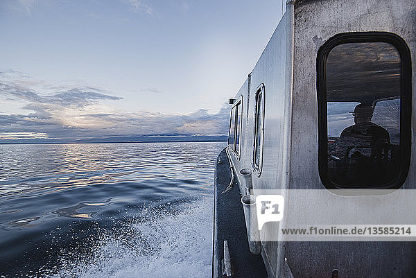 Captain driving boat on tranquil river  Campbell River  British Columbia  Canada