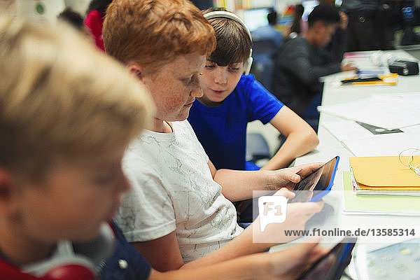 Jungen der Sekundarstufe II nutzen ein digitales Tablet im Klassenzimmer