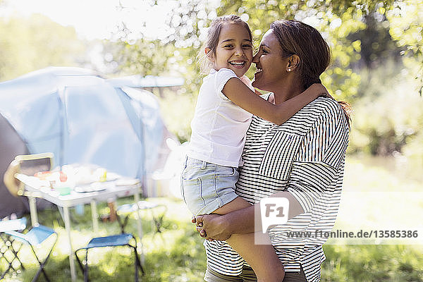 Portrait liebevolle Mutter und Tochter umarmen sich auf einem sonnigen Campingplatz