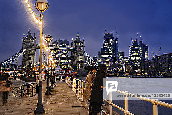 Couple standing along Thames River  London  UK
