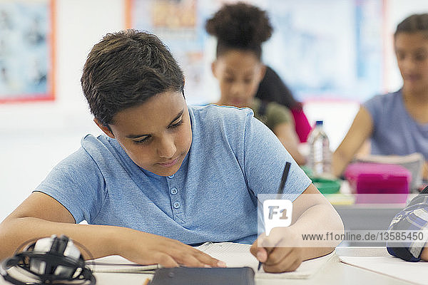 Schüler der Junior High School macht Hausaufgaben im Klassenzimmer