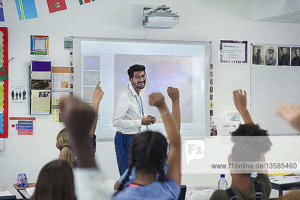Lächelnder männlicher Lehrer  der den Unterricht im Klassenzimmer leitet