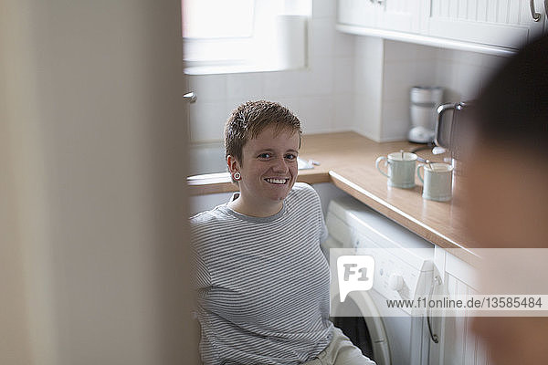 Portrait confident young woman in wheelchair in apartment kitchen