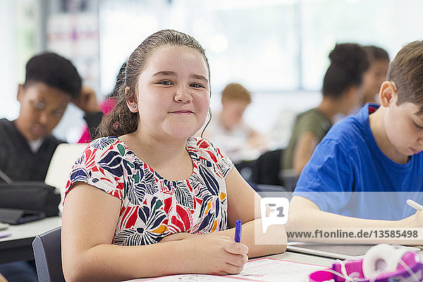 Portrait lächelnd  zuversichtlich Junior High School Mädchen studieren im Klassenzimmer