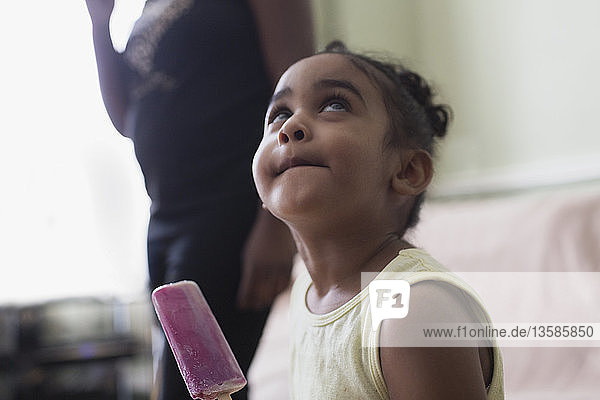 Cute toddler girl eating flavored ice