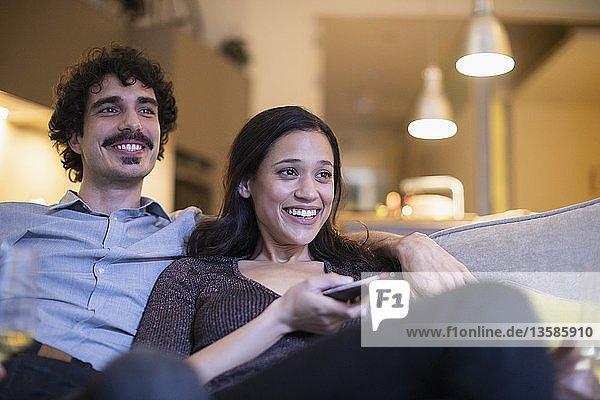 Glückliches Paar beim Fernsehen auf dem Sofa