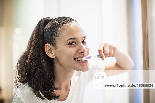 Portrait confident woman brushing teeth