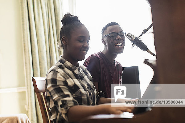 Bruder und Schwester im Teenageralter spielen Klavier und singen