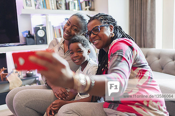 Multi-generation family taking selfie with camera phone in living room